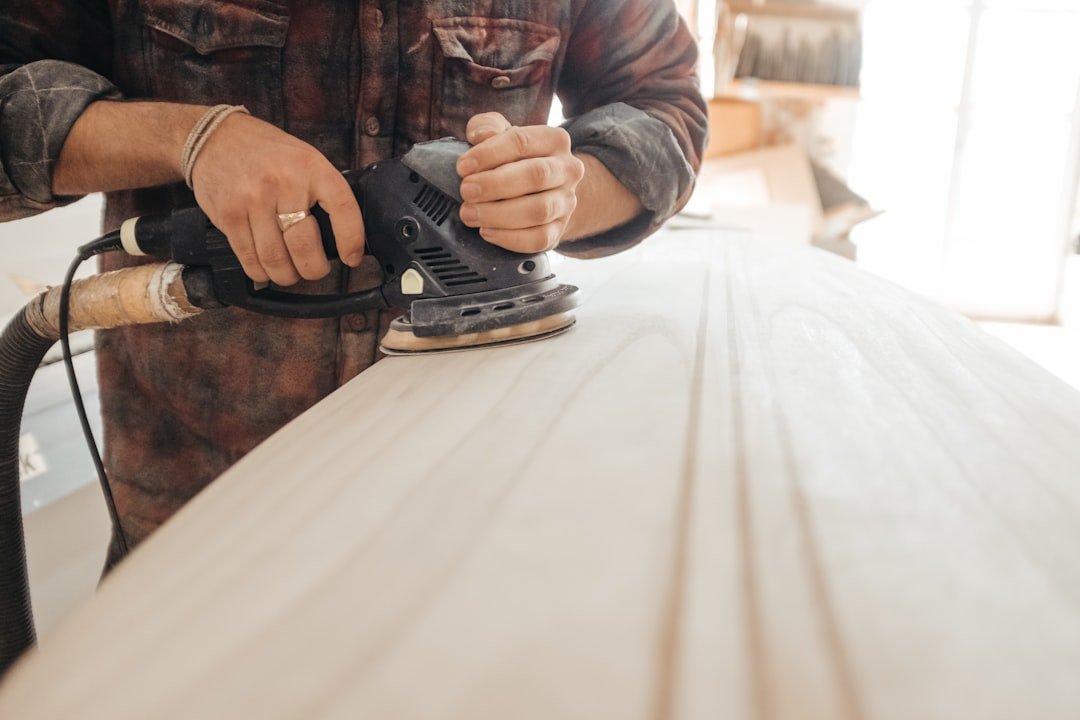 man-using-sander-on-beige-wooden-surface-mlo6ilubada